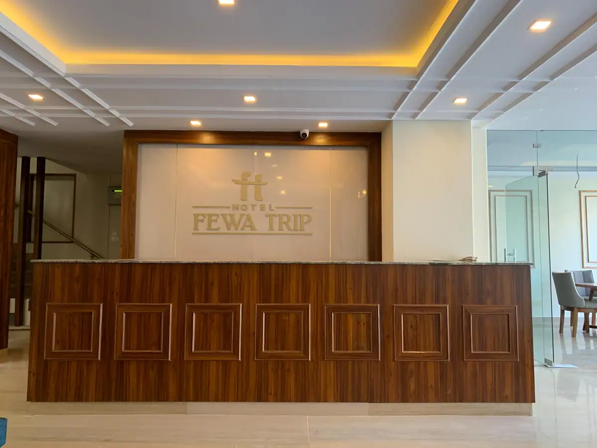Reception desk with the Fewa Trip logo on the wall