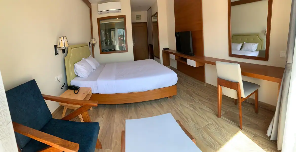 Bright premier room with lounge chair, coffee table and king bed
